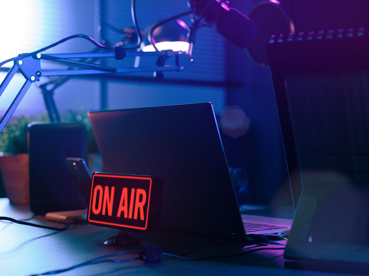 A photo of a radio station studio with an “on air” sign